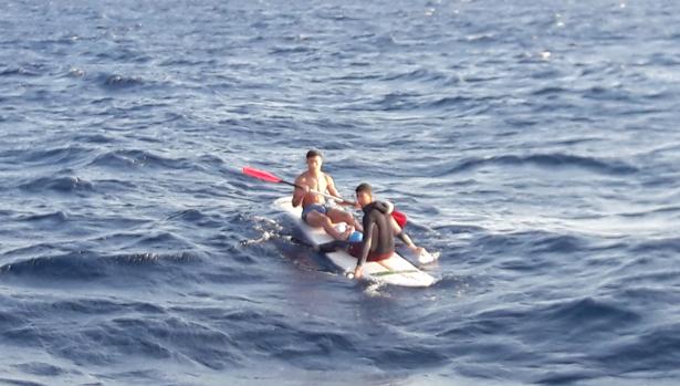 Inmigrantes navegan sobre tablas de surf para llegar su destino